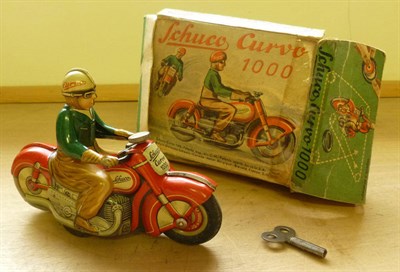 Lot 108 - A Boxed Schuco Clockwork Tinplate Curvo 1000 Motorcycle, with green jacketed rider on red...