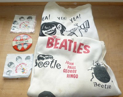 Lot 304 - Beatles Memorabilia, comprising two printed sweat shirts, a large tin lapel badge and two...