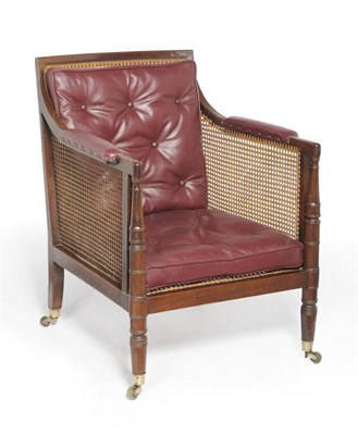 Lot 1436 - A Regency Mahogany Bergere ,circa 1820 with cane back, seat and sides, the padded downswept...