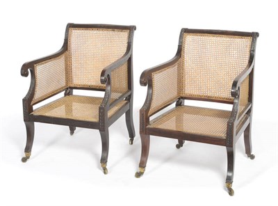 Lot 1437 - A Pair of Mahogany Bergeres, circa 1900-1920, with cane backs, sides and seats, the slightly arched