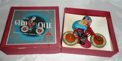 Lot 99 - A Boxed Tri-ang Gyro-Cycle Mechanical Toy, with red framed cycle, Tri-ang Cord wheels, blue...