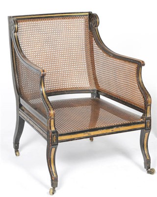 Lot 1522 - A Regency Ebonised and Parcel Gilt Bergere, with cane back, sides and seat, the moulded top...