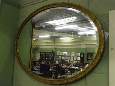 Lot 1529 - A Gilt and Gesso Oval Wall Mirror, late 19th century, the bevelled glass plate within a fluted...