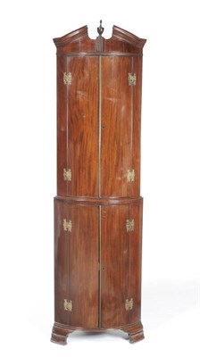 Lot 1538 - A George III Mahogany Bowfront Standing Corner Cupboard, the broken pediment centred by an urn...