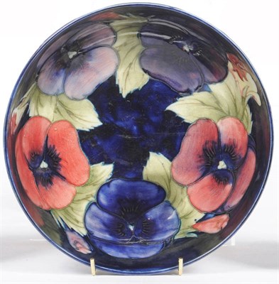 Lot 1584 - A William Moorcroft "Pansy" Bowl, on a dark blue ground, impressed factory mark and painted...