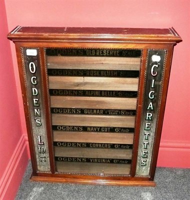 Lot 294 - A Mahogany Wall Mounted Ogden's Cigarette Dispenser, the glazed fascia labelled in black and...