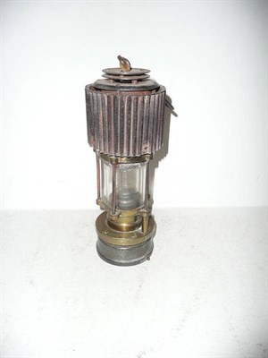 Lot 297 - A Patterson Type H.C.P Miners Safety Lamp No.517, with corrugated tin hood, brass body and...