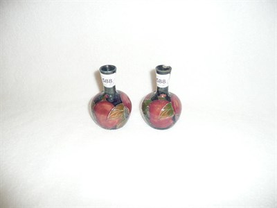 Lot 1588 - A Pair of William Moorcroft "Pomegranate" Vases, on a green/blue ground, impressed factory...