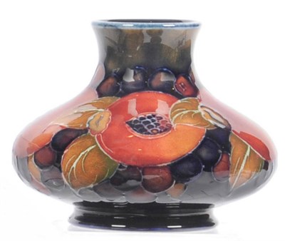 Lot 1590 - A William Moorcroft "Pomegranate" Squat Vase, with an open and closed pomegranate, on a blue...