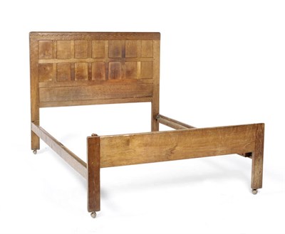 Lot 1638 - A Robert "Mouseman" Thompson Oak 4'6 Panelled Bedstead, dated 1935, the panelled headboard with...