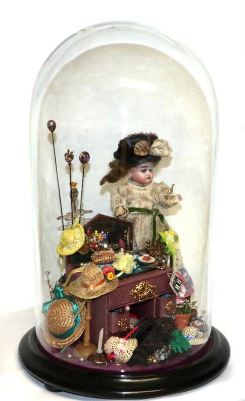 Lot 2002 - The Milliner's Shop, comprising a small bisque socket head doll with blue eyes, open mouth, on...