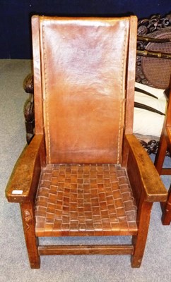 Lot 1653 - A Robert "Mouseman" Thompson Oak Smoker's Chair, leather solid back and interwoven strap seat, with