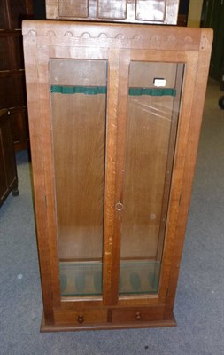 Lot 1679 - A Robert "Mouseman" Thompson Oak Gun Cabinet, with half penny moulding above glazed doors and...