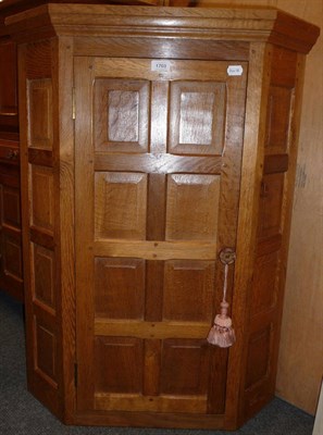 Lot 1703 - A Colin "Beaverman" Almack Oak Panelled Hanging Corner Cupboard, fitted shelf inteiror, with carved