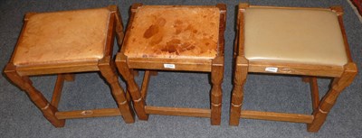 Lot 1704 - Three Colin "Beaverman" Almack Oak Stools, on four octagonal legs joined by a stretcher, each...