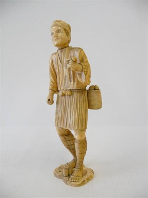 Lot 240 - A Japanese Walrus Ivory Carved Figure of a Fisherman, late Meiji period (1868-1912), standing...