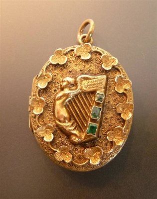 Lot 442 - An Emerald Set Locket, the oval locket with an applied motif of a stringed harp, the outer edge...