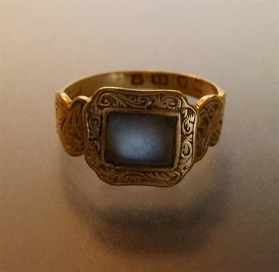 Lot 457 - An 18 Carat Gold Moonstone Memorial Ring, an oblong foil backed moonstone within an engraved border