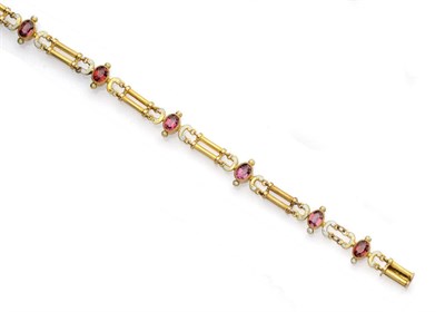 Lot 478 - A Garnet and Enamel Bracelet, oval cut garnets within fancy white enamel frames alternated with...