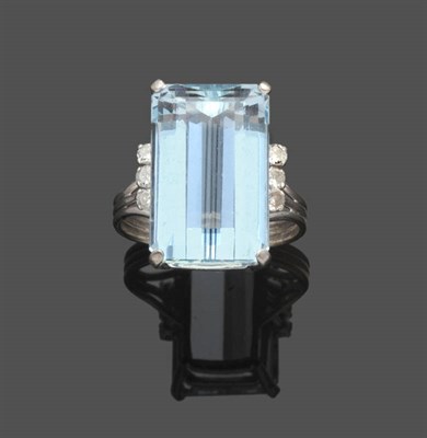 Lot 493 - An Aquamarine and Diamond Ring, the emerald-cut aquamarine held in a white four claw setting is...