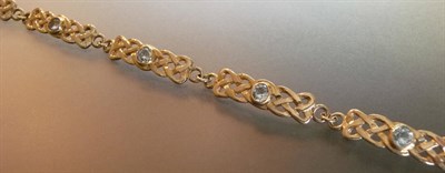 Lot 499 - A 9 Carat Gold Blue Topaz Bracelet, the Celtic links each set centrally with a round brilliant...