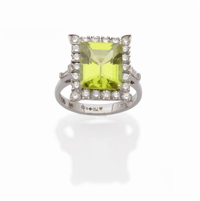 Lot 506 - An 18 Carat White Gold Peridot and Diamond Cluster Ring, a step cut peridot within a border of...