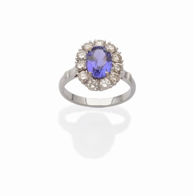 Lot 507 - An 18 Carat White Gold Tanzanite and Diamond Cluster Ring, the oval cut tanzanite within a...