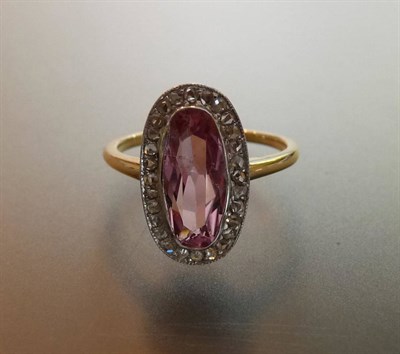 Lot 515 - A Pink Topaz and Diamond Cluster Ring, the oval cut pink topaz within a border of rose cut diamonds