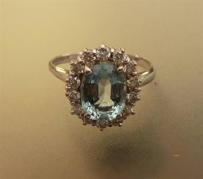 Lot 534 - An 18 Carat White Gold Aquamarine and Diamond Cluster Ring, the oval mixed cut aquamarine...