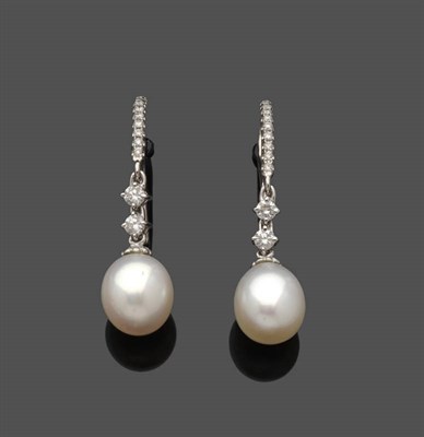 Lot 540 - A Pair of Diamond and Cultured Pearl Drop Earrings, a row of tiny diamonds suspends two round...