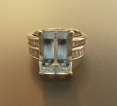 Lot 547 - An Aquamarine and Diamond Art Deco Style Ring, the central baguette cut aquamarine in a white...