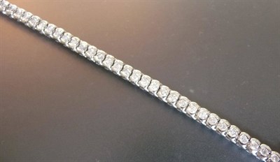 Lot 551 - An 18 Carat White Gold Diamond Line Bracelet, the round brilliant cut diamonds held in chunky...