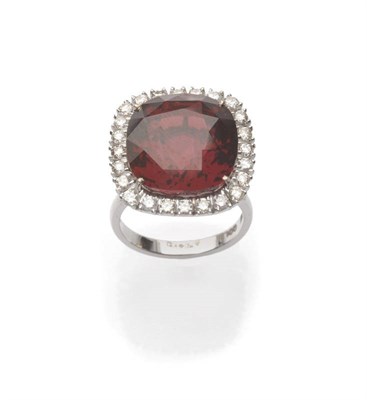 Lot 555 - An 18 Carat White Gold Garnet and Diamond Cluster Ring, a cushion cut garnet within a border of...