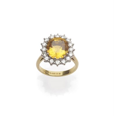 Lot 558 - An 18 Carat Gold Yellow Beryl and Diamond Cluster Ring, the step cut yellow beryl within a...