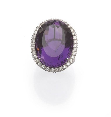 Lot 559 - An 18 Carat White Gold Amethyst and Diamond Cluster Ring, the large oval cut amethyst within a...