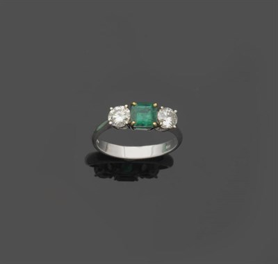 Lot 577 - An 18 Carat White Gold Emerald and Diamond Three Stone Ring, the square emerald-cut emerald flanked