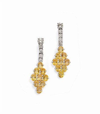 Lot 596 - A Pair of 18 Carat White Gold Yellow Sapphire and Diamond Drop Earrings, a round brilliant cut...