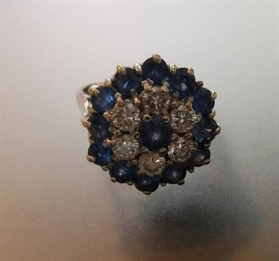 Lot 602 - A Sapphire and Diamond Cluster Ring, comprising alternating rows of round brilliant cut...