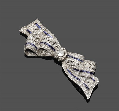 Lot 606 - A Diamond and Sapphire Bow Brooch, a round brilliant cut diamond centres the stylised bow, set...