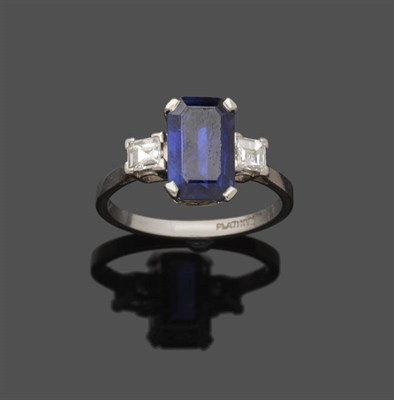 Lot 616 - A Sapphire and Diamond Three Stone Ring, the emerald-cut sapphire flanked by a carré cut...