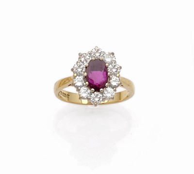 Lot 625 - An 18 Carat Gold Ruby and Diamond Cluster Ring, the oval cut ruby within a border of round...