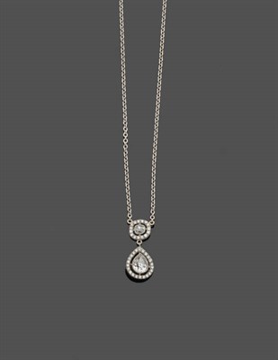 Lot 635 - A Diamond Pendant on Chain, a cushion cut diamond within a diamond set frame suspends a pear...