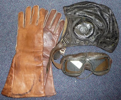 Lot 65 - A Second World War Leather Flying Helmet and Goggles, the leather goggles strap stamped with...