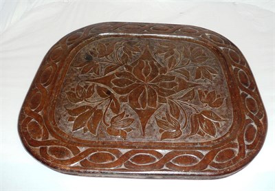 Lot 1021 - A Walnut Foliate Carved Panel or Baking Board, early 20th century, rounded rectangular with...