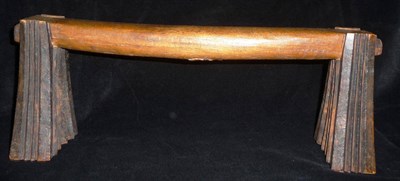 Lot 197 - A Zulu Carved Wood Headrest, the slightly curved pillow raised upon dark stained fluted fanned...