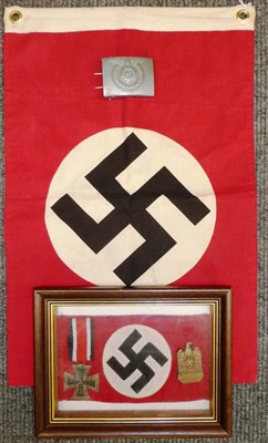 Lot 110 - A German Iron Cross, Second Class, an NSDAP badge and a reproduction armband, contained in a sealed