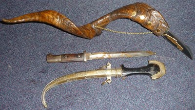 Lot 146 - A Moroccan Jambiya, with curved double edge steel blade, ebonised wood and brass hilt, the...