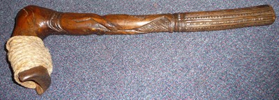 Lot 233 - A Maori Wood Adze, of light brown colour, carved as a stylised figure of a man, his angled head...