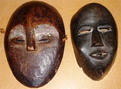 Lot 274 - A Dan, Ivory Coast Wood Face Mask, of oval form with domed forehead pierced elliptical eyes,...