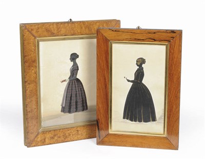 Lot 1081 - A Silhouette Standing Portrait of a Young Woman, circa 1840, her hair in a bun, holding a...